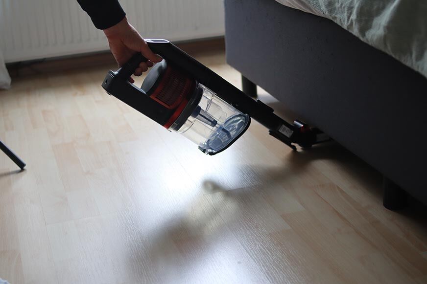Shark Anti Hair Wrap Flexoloxy is seen cleaning under furniture.